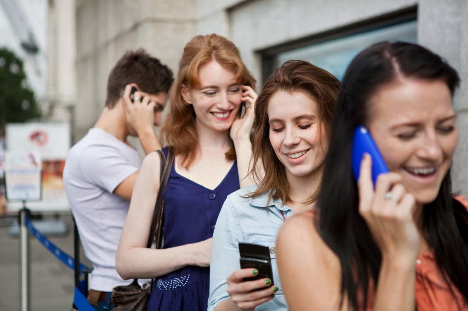 Young men and women using mobile phones