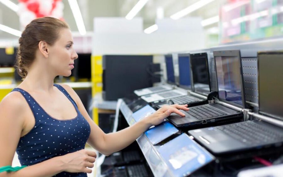 woman looking at laptops in store